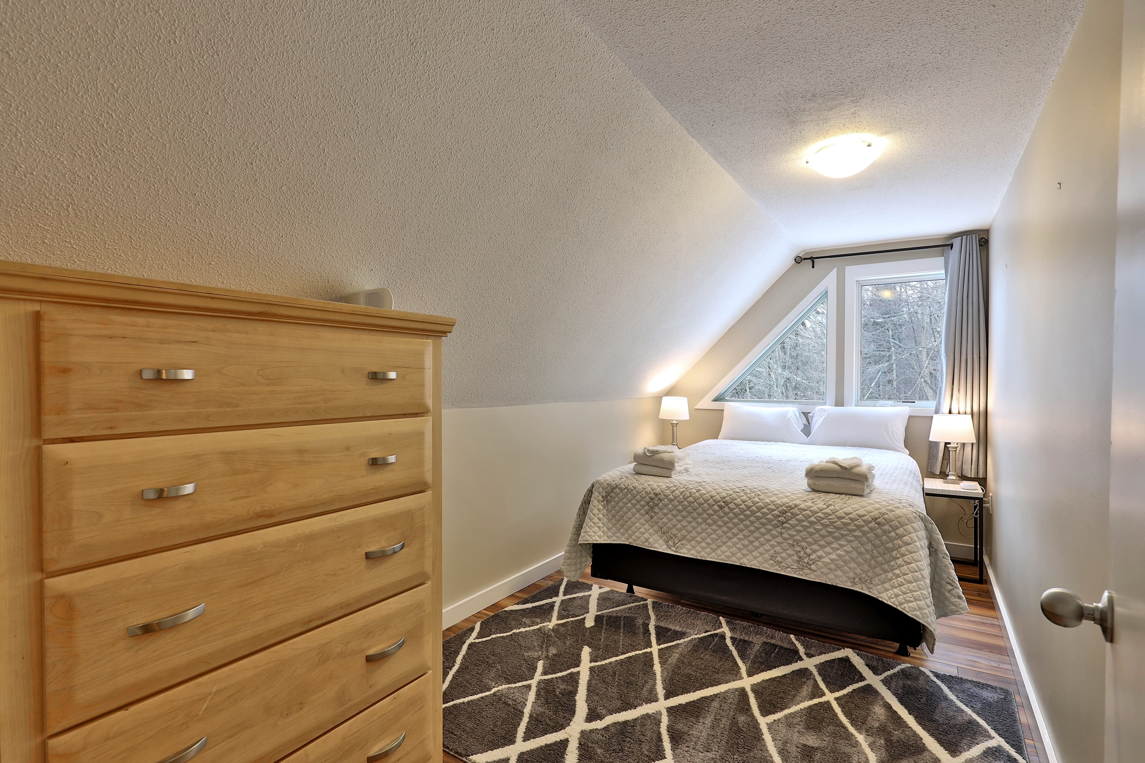 Hospitable bedroom with a queen bed and dresser for your belongings.