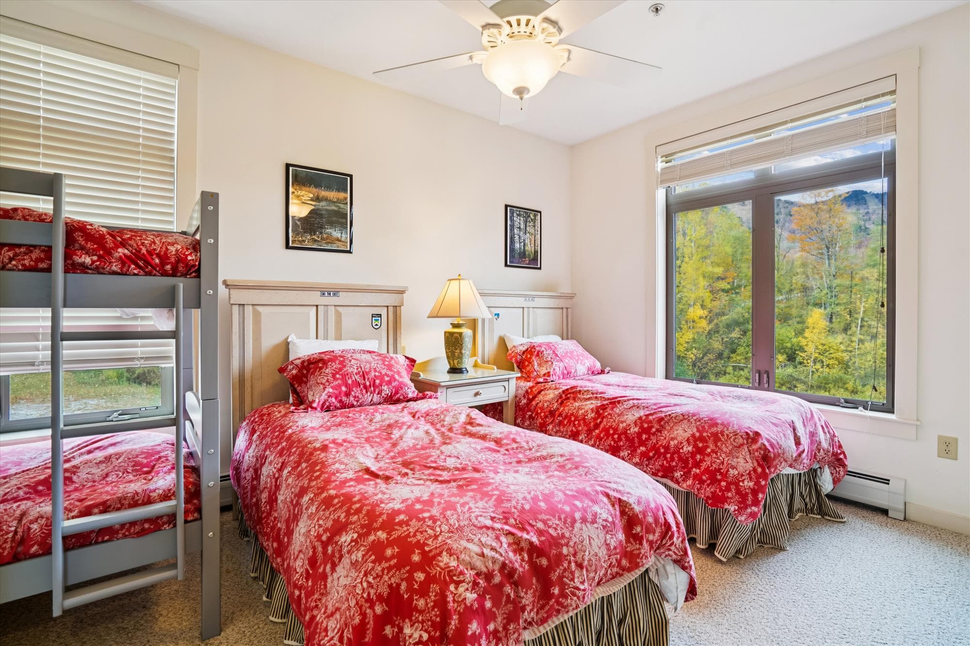 Bright bedroom with two twin beds and a bunk set, ideal for families or friends. Large windows bring in mountain views and natural light, creating a relaxed and comfortable place to rest and recharge.
