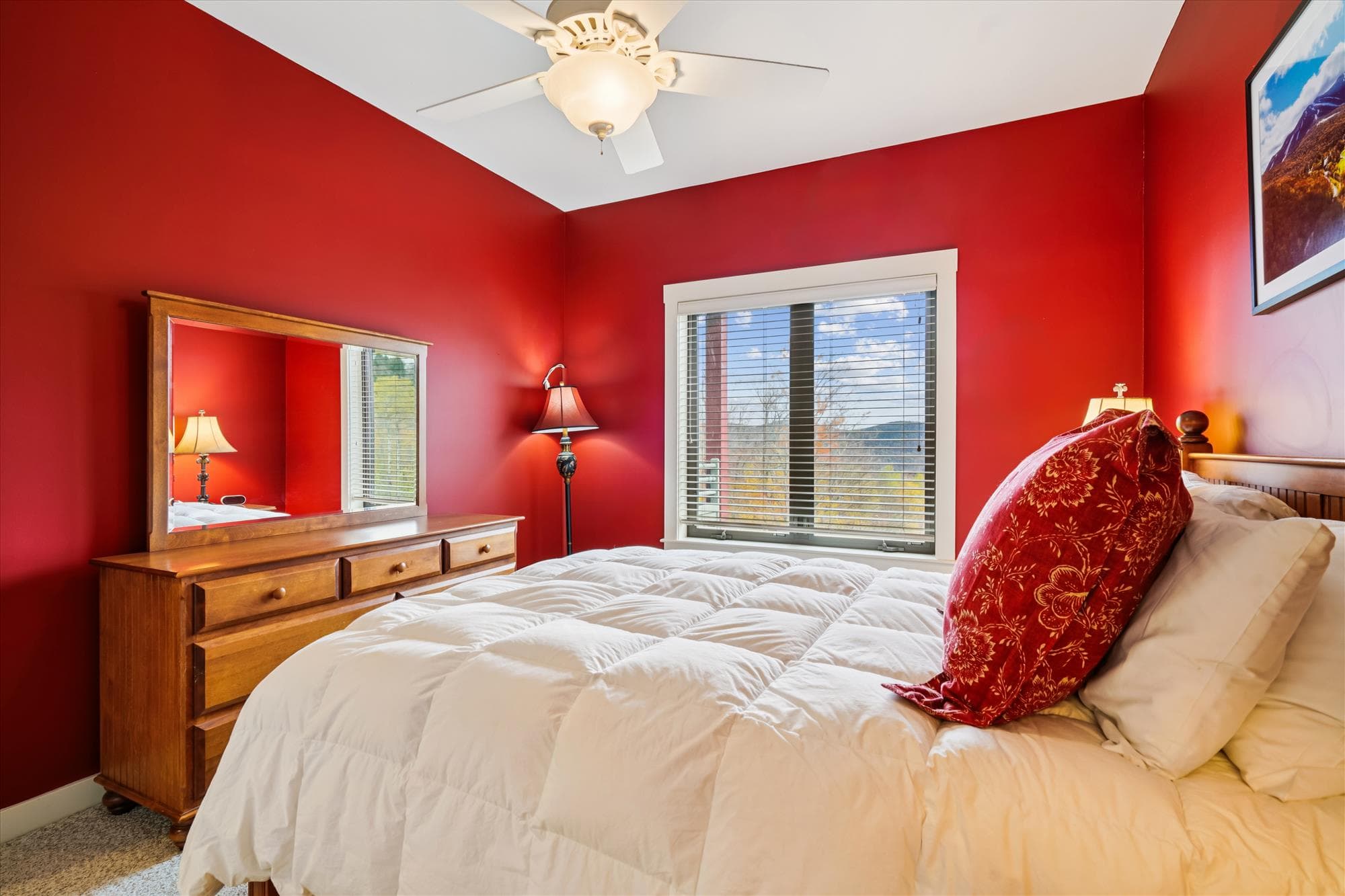 Wake up to soft mountain light and settle into a restful queen bed surrounded by warm red tones and wood accents. The private bath makes this space ideal for couples or friends sharing the adventure.