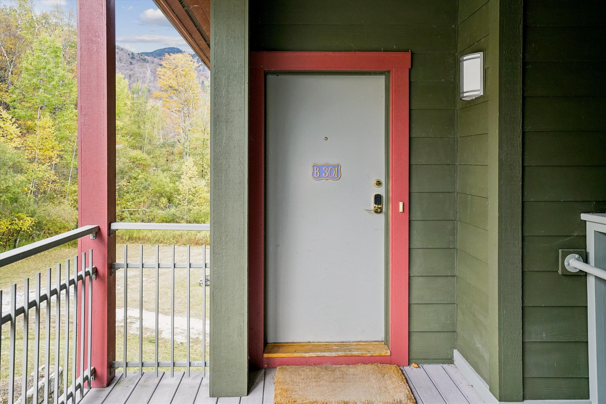 Exterior entrance to Lodges B301, located on the upper level of the building with surrounding mountain views and a quiet outdoor landing.