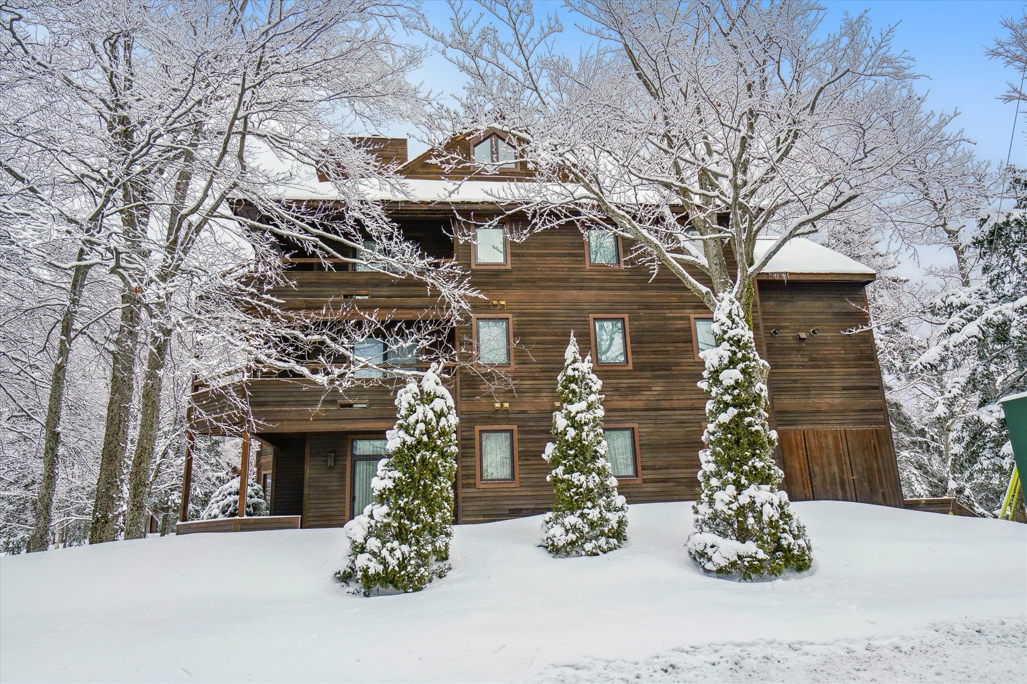 Classic alpine-style condominium buildings nestled among the trees in the Highridge community.