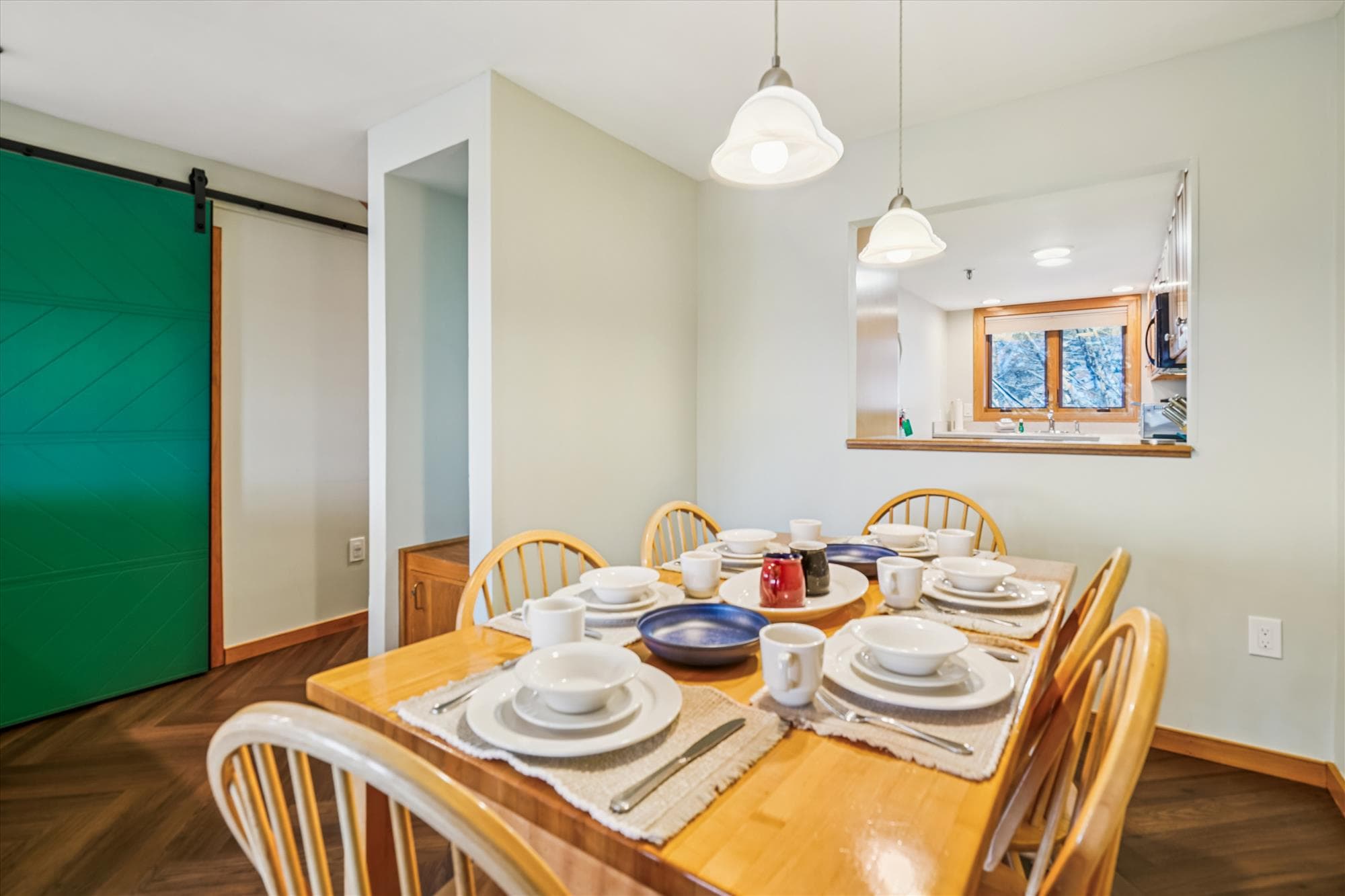 The dining table sits beside a convenient kitchen pass-through, making serving meals and gathering with family and friends easy.