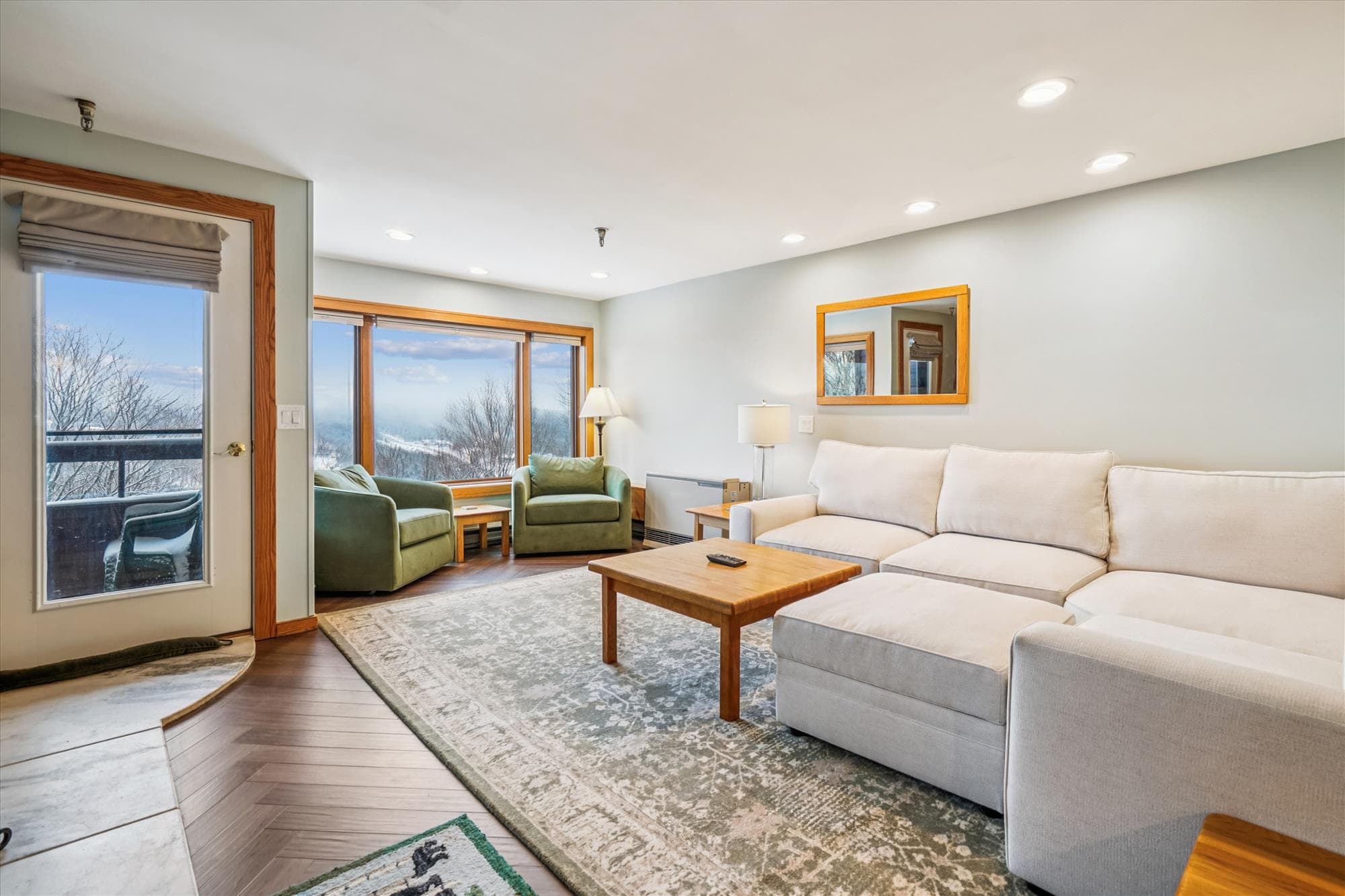 Enjoy relaxing evenings in the spacious living room with plush seating and large windows that fill the space with natural light and mountain scenery.