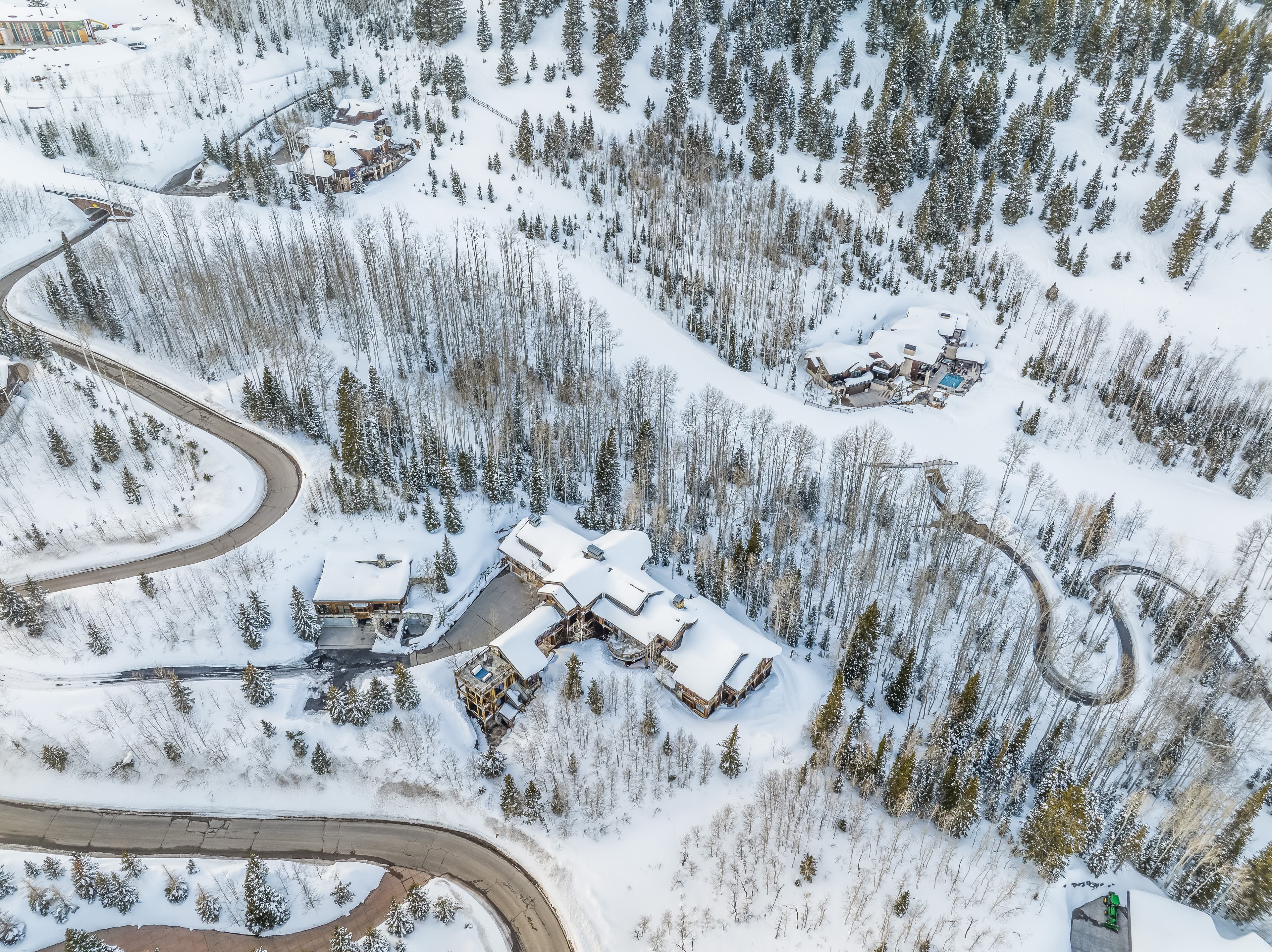 An aerial view of Talus Ridge, showing winding roads around it tracing their way through the snow.