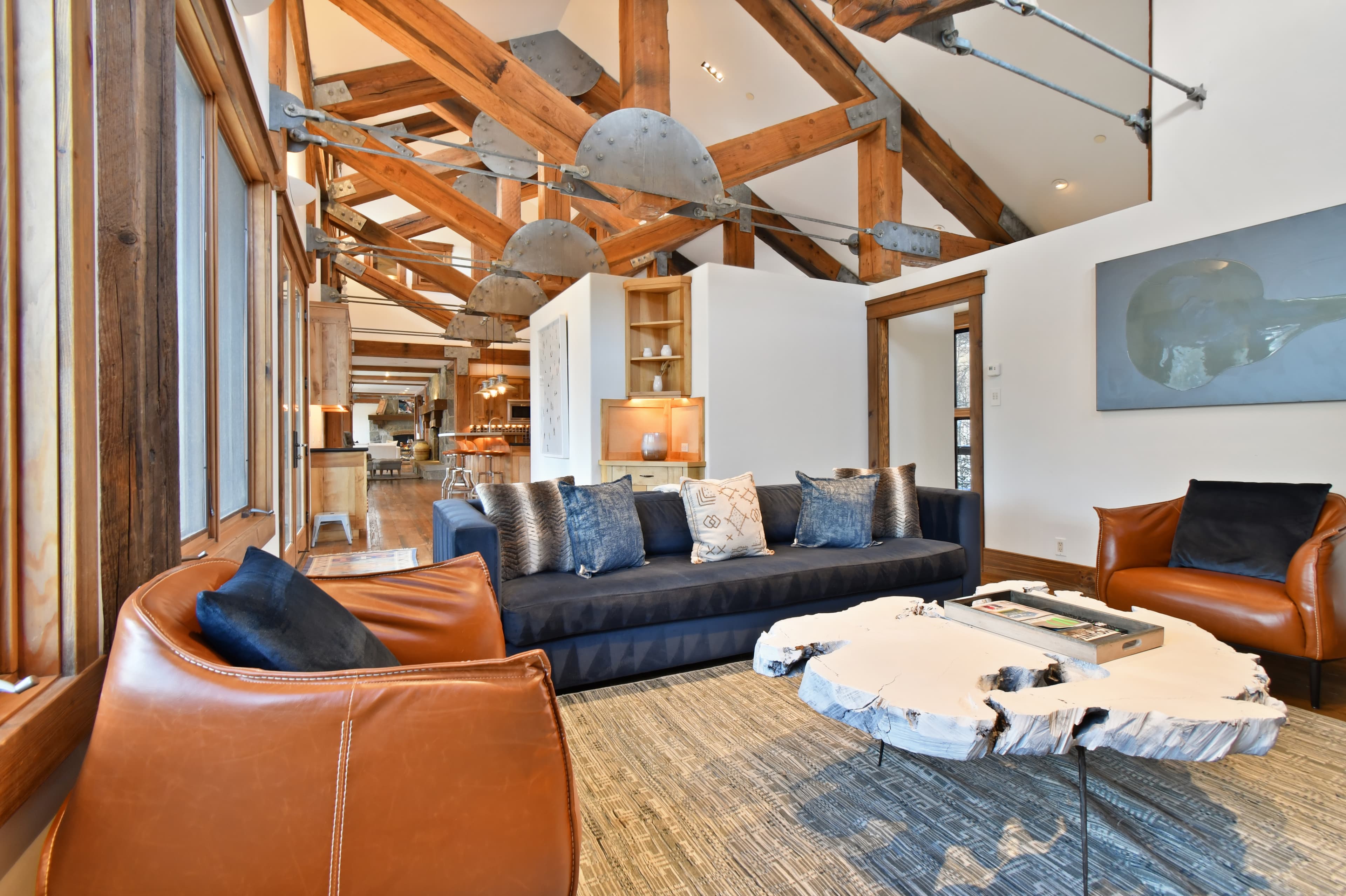 A closer view of one of the leather armchairs in a living area, and the unique wood coffee table in the center of the room.