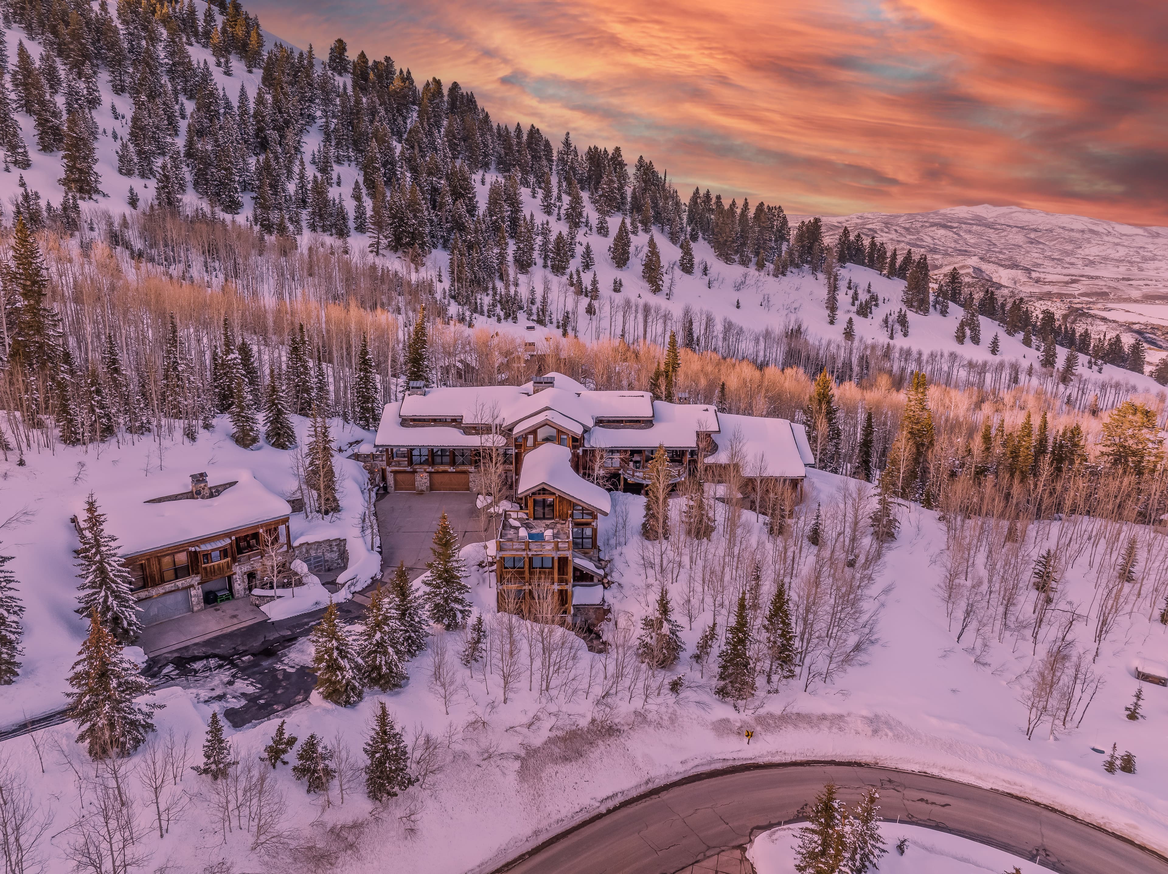 A road carves through the snow in front of this luxury Park City vacation rental.