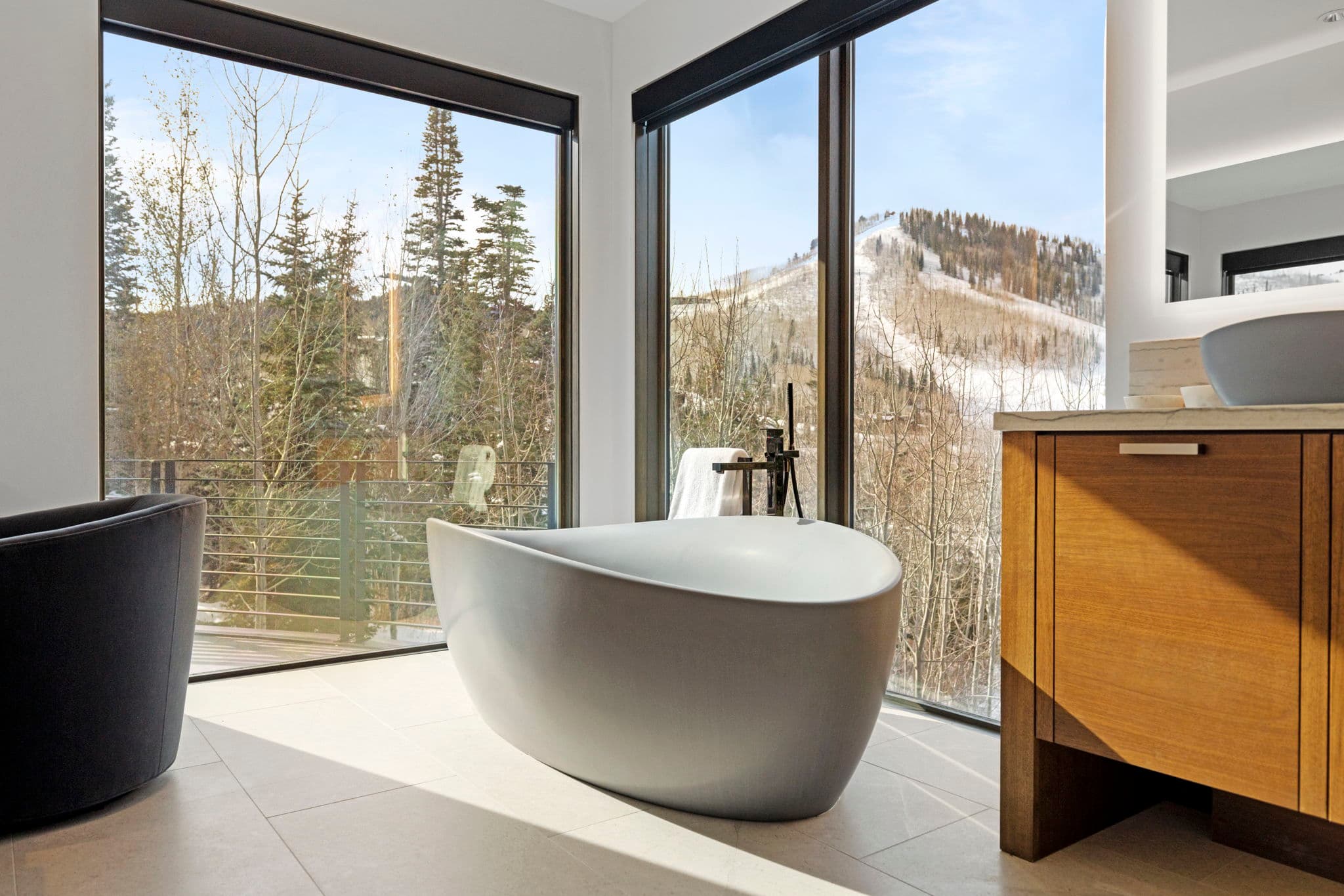 A bathroom with a large tub and floor-to-ceiling windows.
