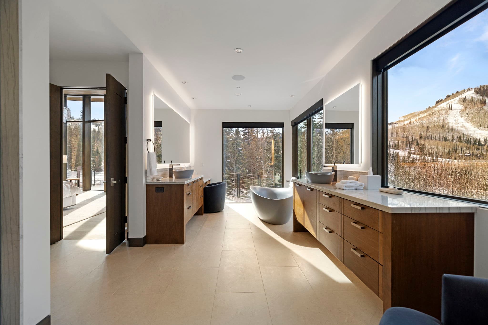 A bathroom with a tub and two sinks with storage space.